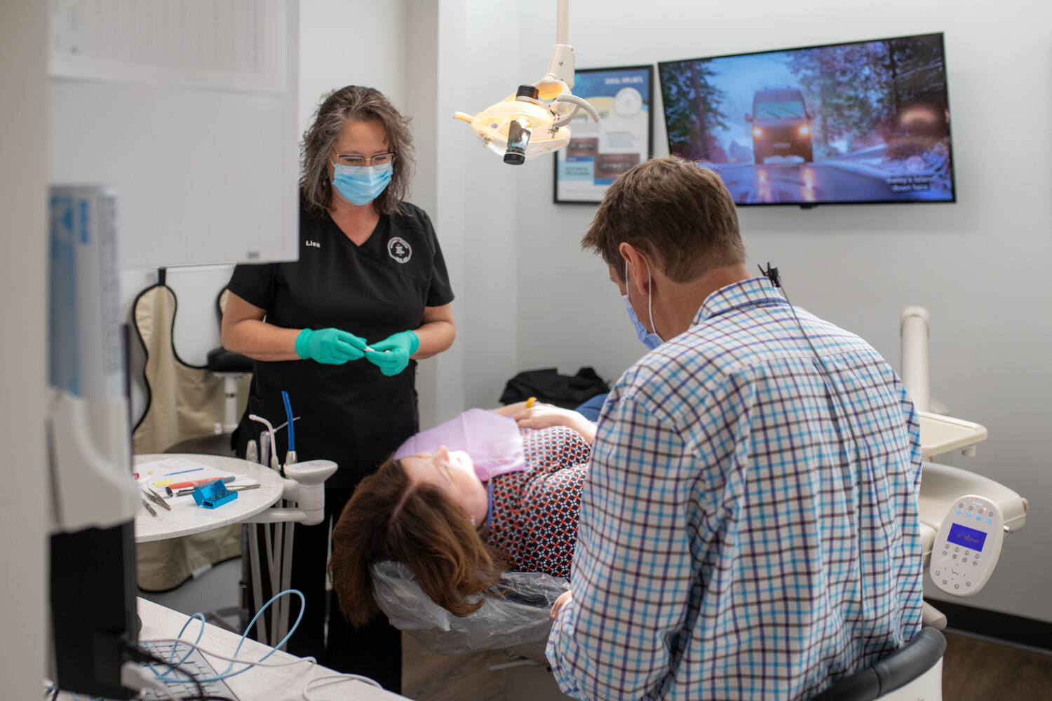 Dental team performing a tooth bonding procedure in a treatment r