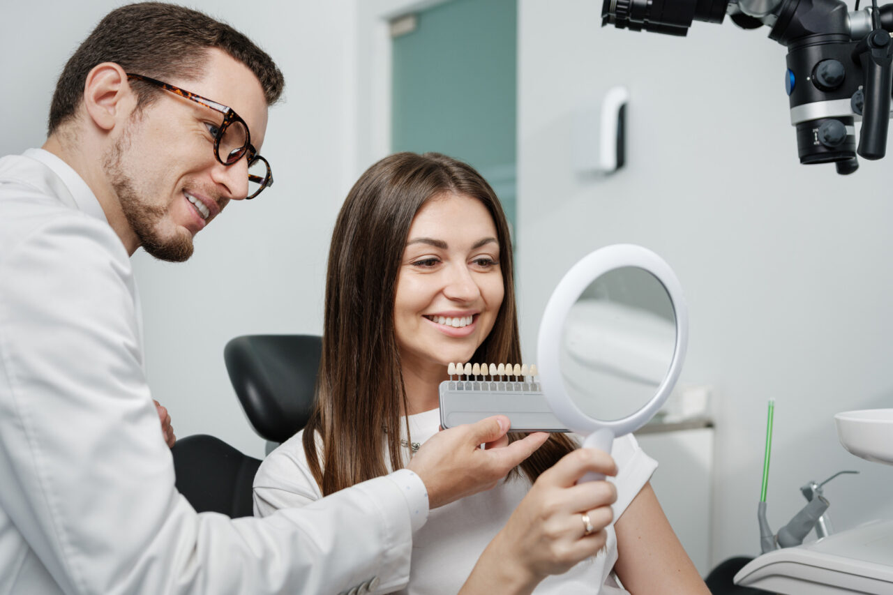 Dentist evaluating tooth shade before starting teeth whitening treatment