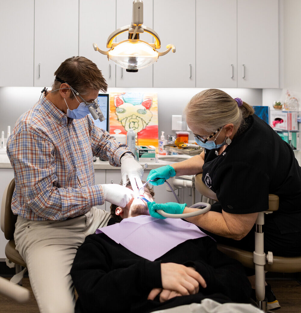 Dentist and assistant performing a routine cleaning during a general dentistry appointment