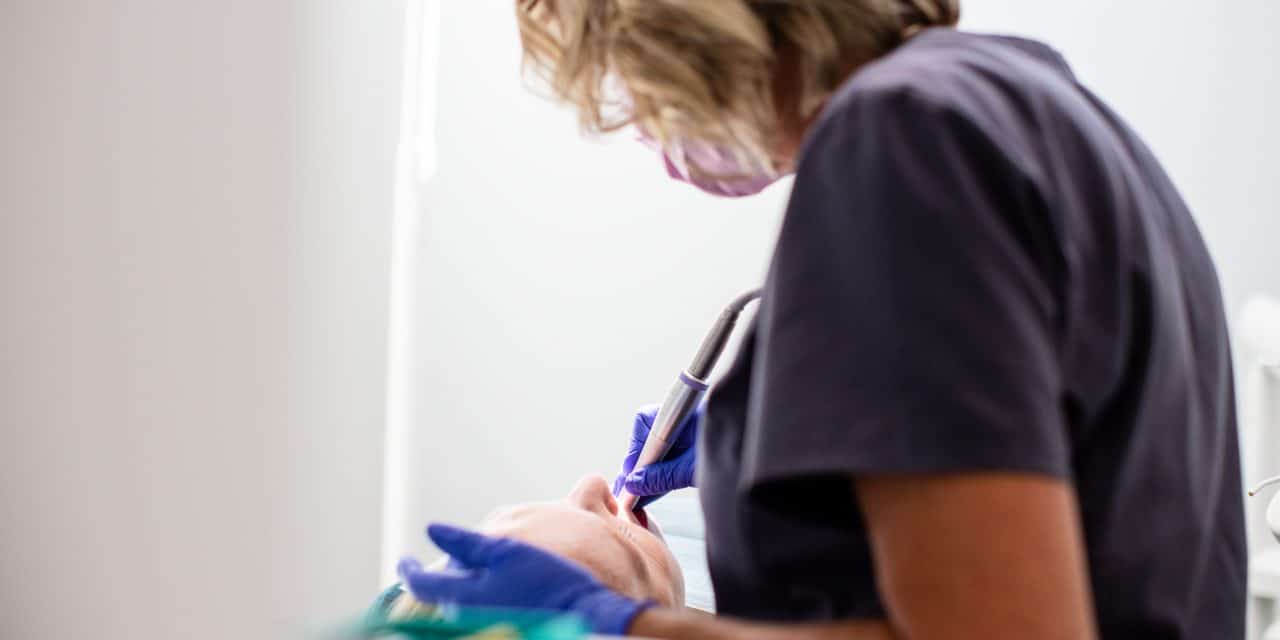 Dental professional evaluating a patient’s teeth during veneer treatment planning