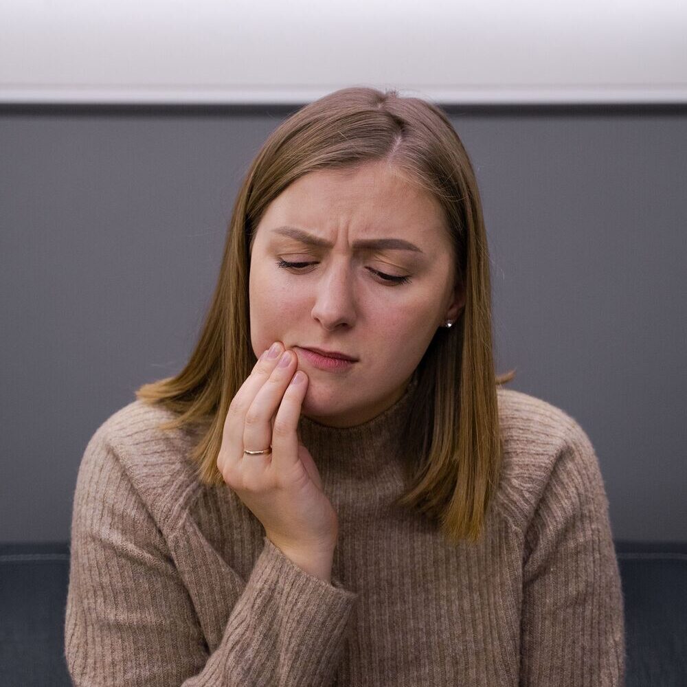 Woman with tooth pain after possible damage to dental work